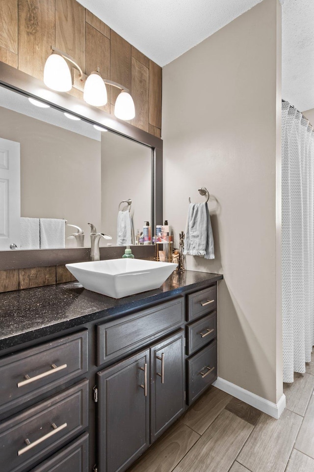 bathroom with vanity, baseboards, wood finished floors, and curtained shower