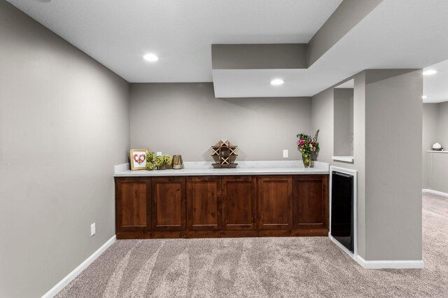 bar featuring light colored carpet, baseboards, beverage cooler, bar area, and recessed lighting