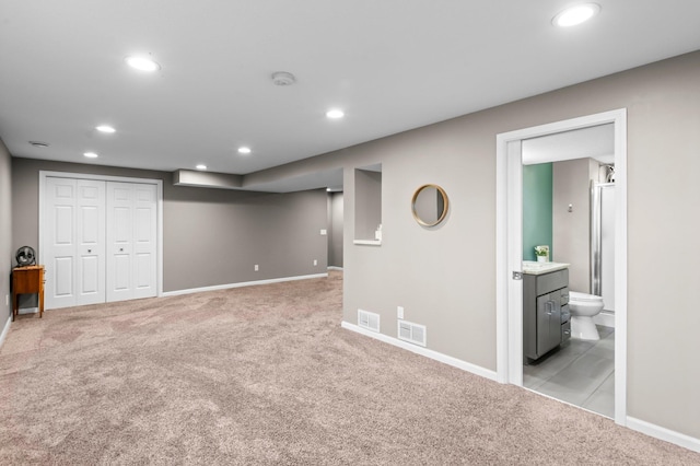 finished below grade area featuring baseboards, light carpet, recessed lighting, and visible vents