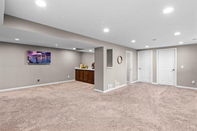 finished basement featuring baseboards, light carpet, recessed lighting, and visible vents
