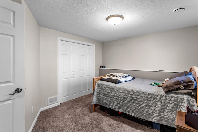 carpeted bedroom featuring a textured ceiling, visible vents, baseboards, and a closet