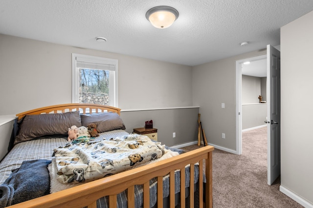 carpeted bedroom featuring baseboards and a textured ceiling