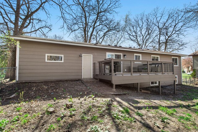 back of property with fence and a wooden deck