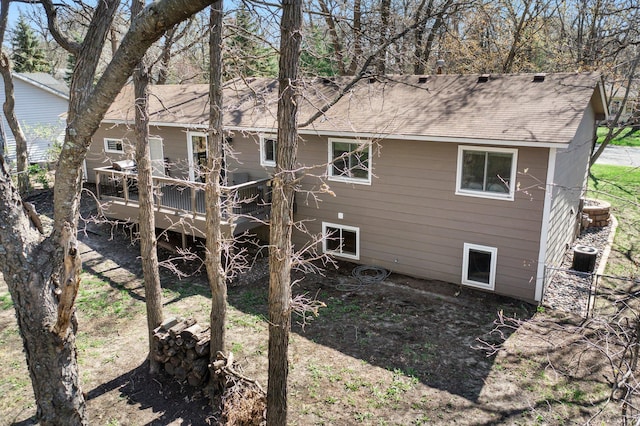 back of house with a shingled roof, central AC, and a deck