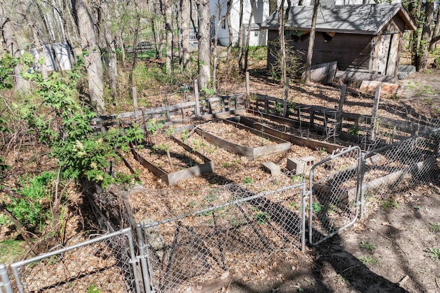 view of yard with fence, a storage unit, a gate, and a vegetable garden