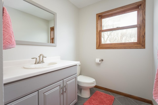 bathroom with tile patterned flooring, baseboards, toilet, and vanity