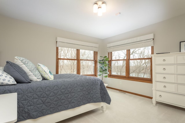 bedroom with visible vents, baseboards, and light colored carpet