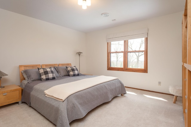 bedroom with light carpet and baseboards