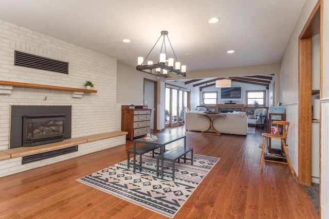 living area featuring recessed lighting, a chandelier, wood finished floors, and a fireplace