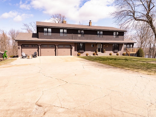 view of front of property with a chimney, a front lawn, concrete driveway, an attached garage, and covered porch