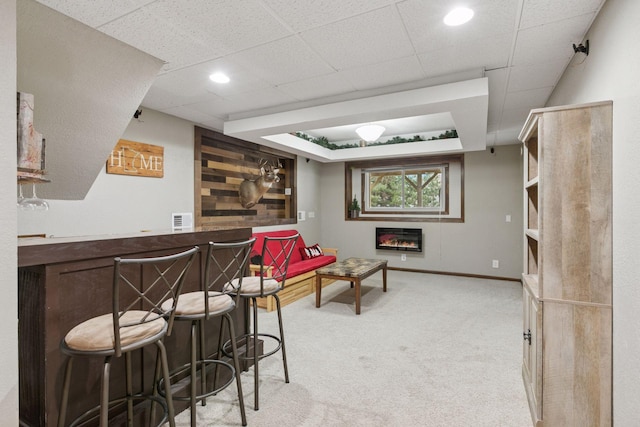 14921 Zeolite St NW, Ramsey, MN 55303 - bar with visible vents, baseboards, a glass covered fireplace, a dry bar, and light carpet