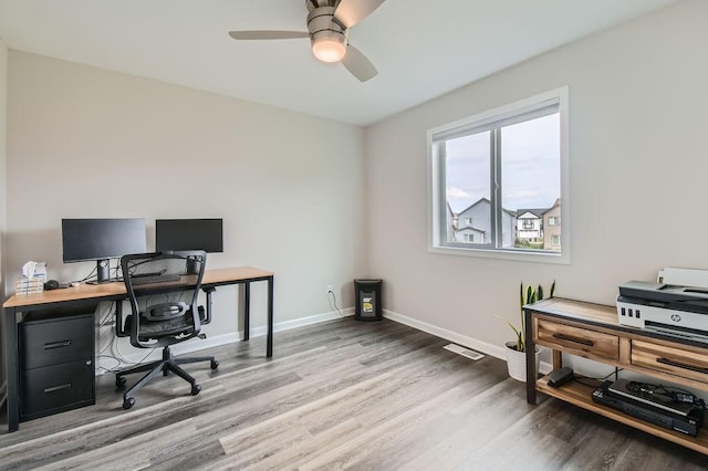 office featuring wood finished floors, visible vents, a ceiling fan, and baseboards