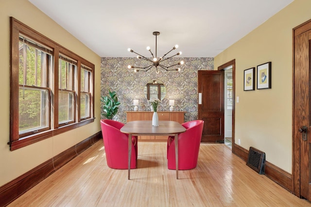 4034 Abbott Ave S, Minneapolis, MN 55410 - dining area featuring baseboards, a chandelier, light wood-style floors, and an accent wall