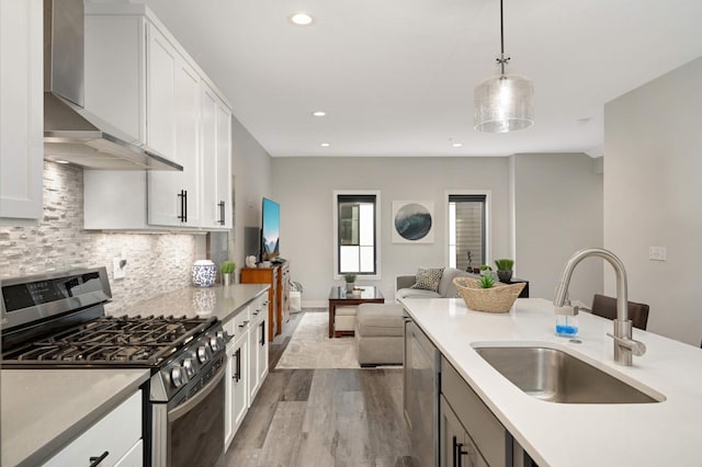 6369 16th Ave S, Richfield, MN 55423 - kitchen featuring appliances with stainless steel finishes, wall chimney range hood, wood finished floors, recessed lighting, and light countertops