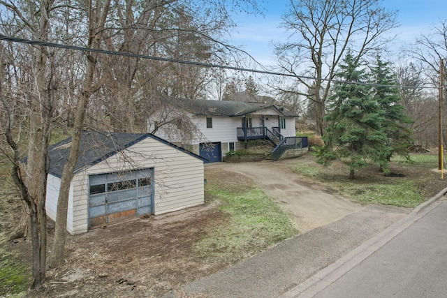 1601 Welland Ave, Minnetonka, MN 55305 - view of front of home with a garage, dirt driveway, a wooden deck, stairway, and an outdoor structure