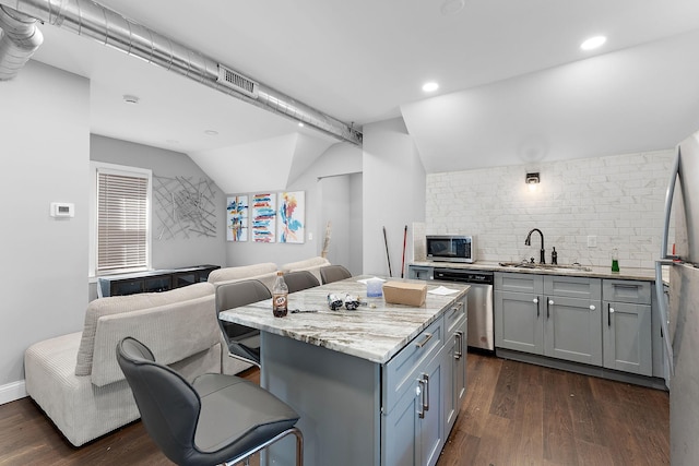 936 Westminster St, Saint Paul, MN 55130 - kitchen with a sink, appliances with stainless steel finishes, a breakfast bar area, lofted ceiling, and tasteful backsplash
