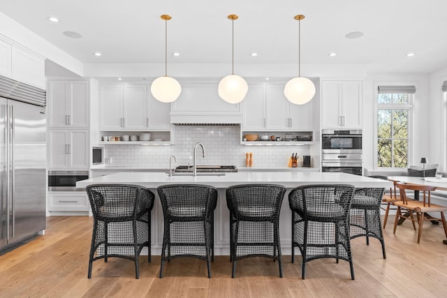 kitchen featuring appliances with stainless steel finishes, open shelves, light countertops, white cabinets, and recessed lighting