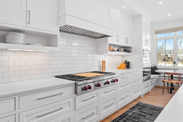 kitchen with open shelves, stainless steel appliances, premium range hood, white cabinetry, and recessed lighting