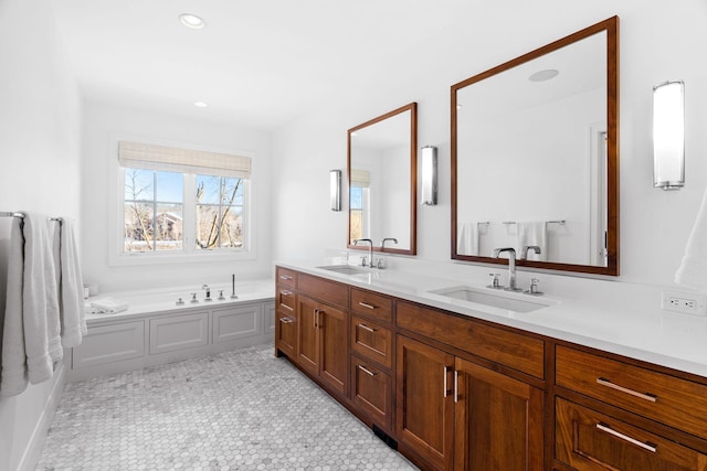 full bathroom with double vanity, a garden tub, and recessed lighting