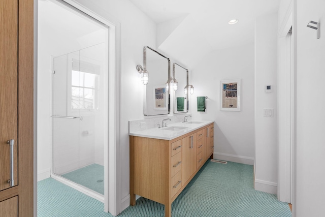 full bath featuring a shower stall, double vanity, baseboards, and recessed lighting