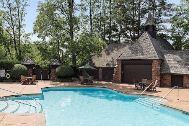 community pool featuring a patio, outdoor dining area, and fence
