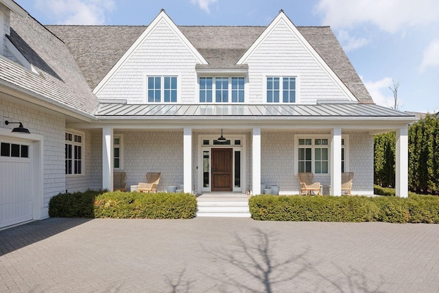 view of front of property featuring a standing seam roof, a porch, and a shingled roof