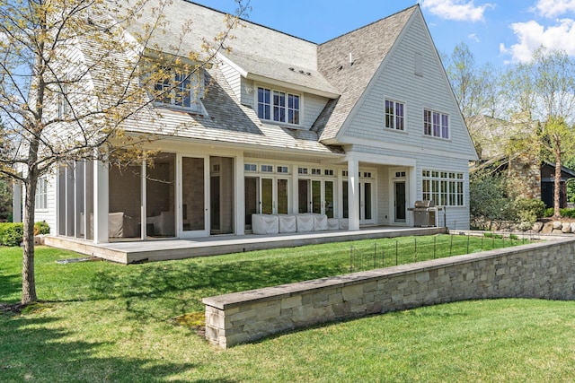 back of house featuring a sunroom and a lawn