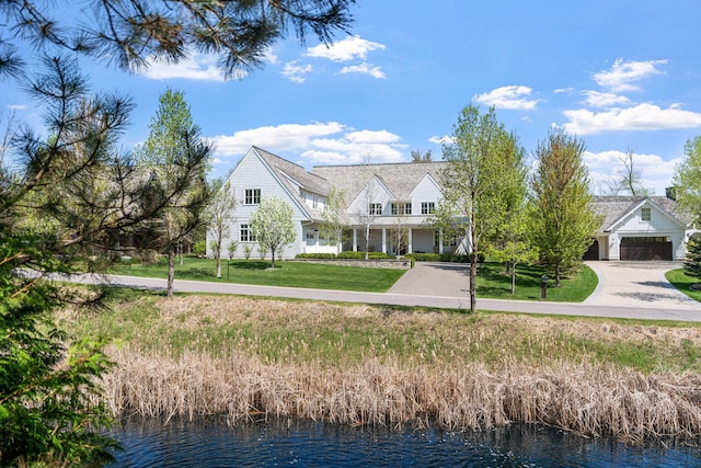 view of front of house featuring a water view, a front yard, and driveway