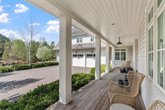 deck featuring covered porch and an attached garage