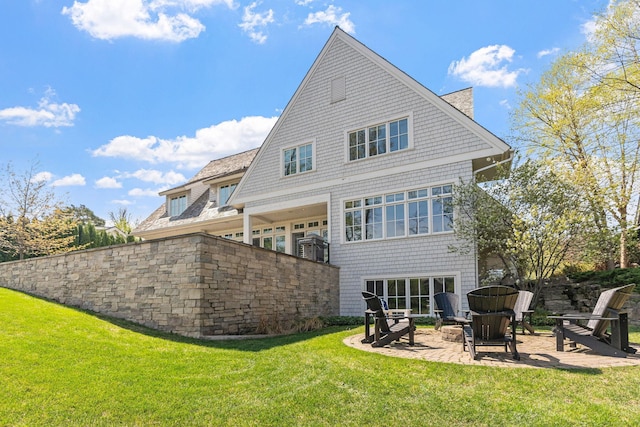 rear view of house featuring a lawn and a patio