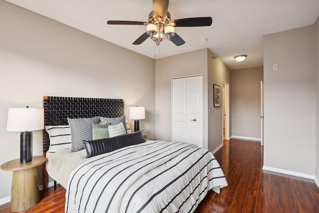 bedroom with ceiling fan, baseboards, wood finished floors, and a closet