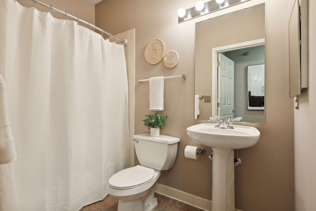 full bathroom featuring baseboards, a sink, a shower with shower curtain, and toilet