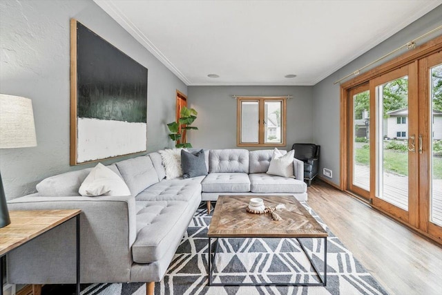 living room with light wood-style floors and ornamental molding