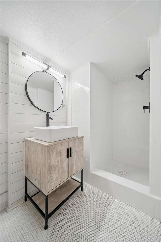 bathroom featuring a tile shower and vanity