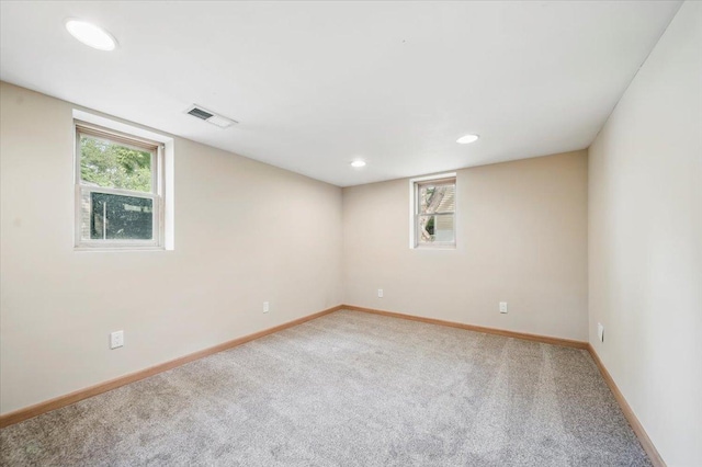 empty room featuring carpet floors, baseboards, and recessed lighting
