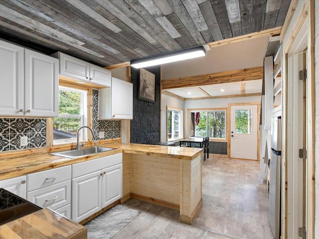 6274 Azalea Rd, Motley Twp, MN 56466 - kitchen with a sink, butcher block counters, a peninsula, white cabinetry, and light wood-style flooring