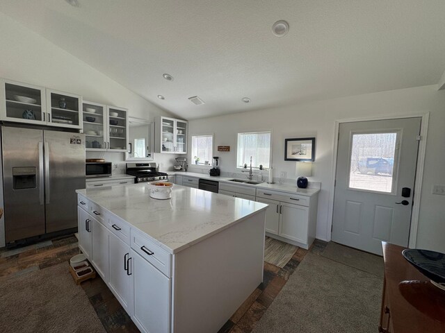 92620 Palon Rd, Sturgeon Lake, MN 55783 - kitchen featuring white cabinets, lofted ceiling, a sink, a kitchen island, and appliances with stainless steel finishes