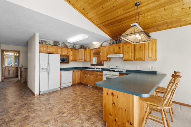 kitchen featuring dark countertops, white appliances, under cabinet range hood, a sink, and vaulted ceiling