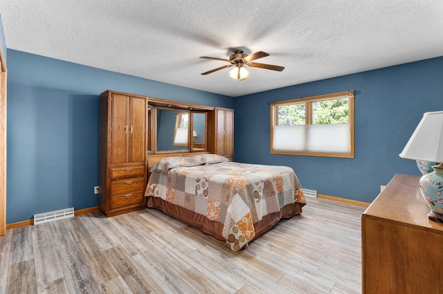 bedroom featuring baseboards, light wood-type flooring, and visible vents