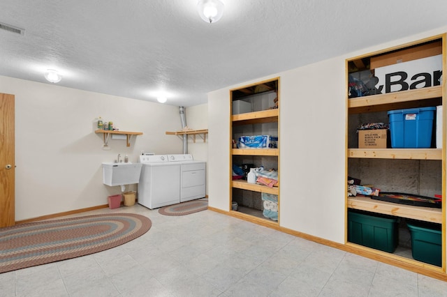 laundry room with laundry area, separate washer and dryer, a textured ceiling, baseboards, and visible vents
