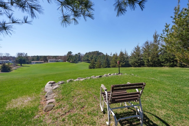 view of home's community featuring view of golf course and a yard