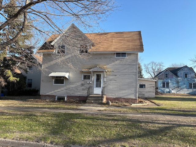 traditional-style home featuring a front yard and entry steps