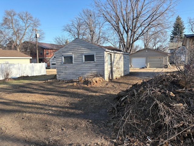 detached garage featuring fence