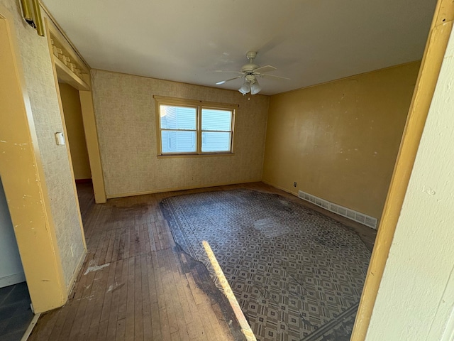 unfurnished bedroom with ceiling fan, visible vents, baseboards, and hardwood / wood-style floors