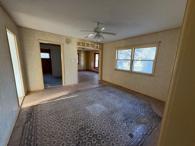 unfurnished room with ceiling fan, baseboards, and wood finished floors