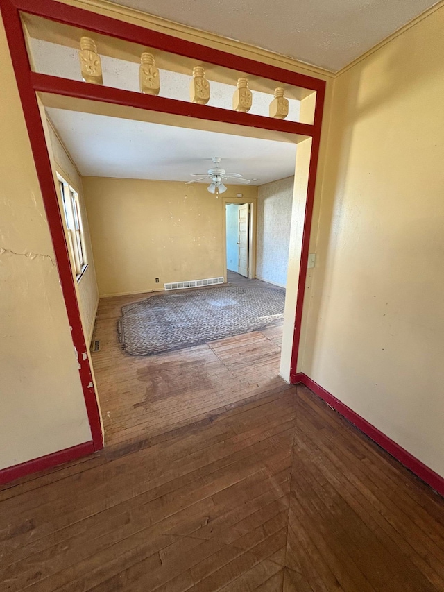 spare room featuring visible vents, wood finished floors, baseboards, and ceiling fan