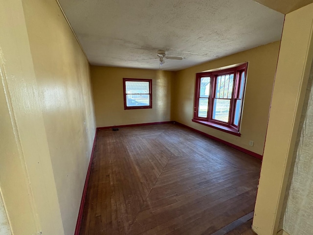 empty room featuring ceiling fan, a textured ceiling, and baseboards