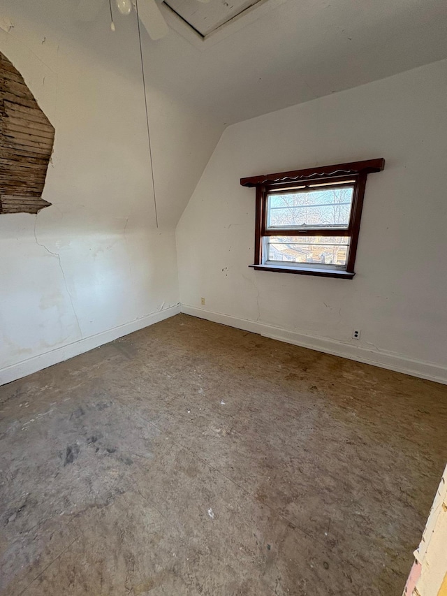 additional living space with a ceiling fan, baseboards, and vaulted ceiling