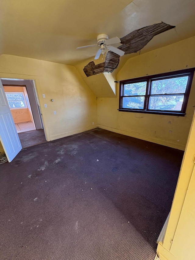 bonus room featuring vaulted ceiling, ceiling fan, baseboards, and a healthy amount of sunlight