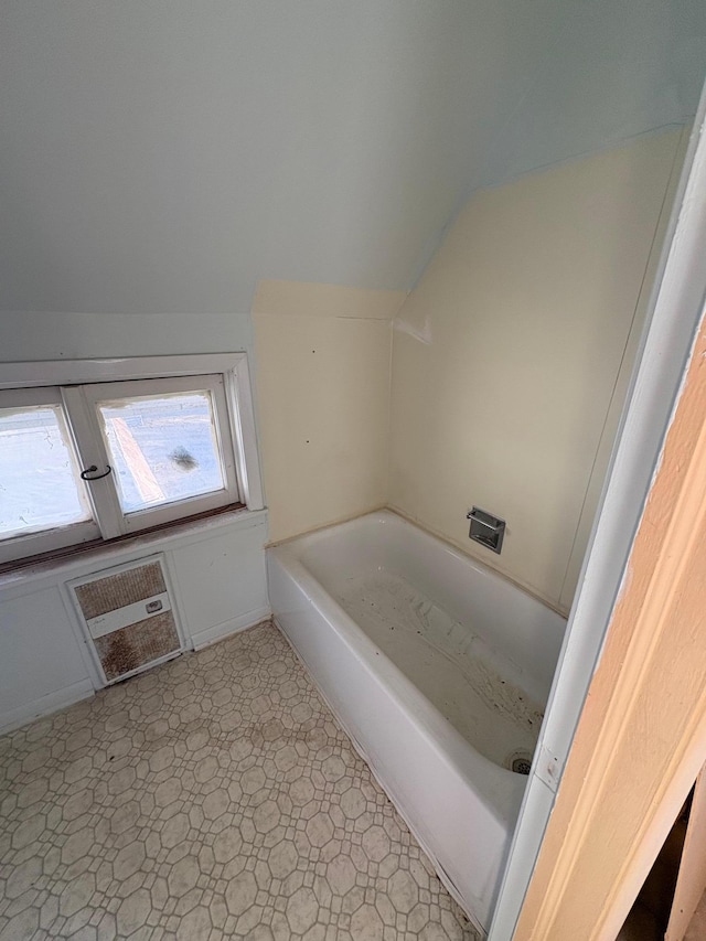 full bath featuring lofted ceiling and a tub to relax in